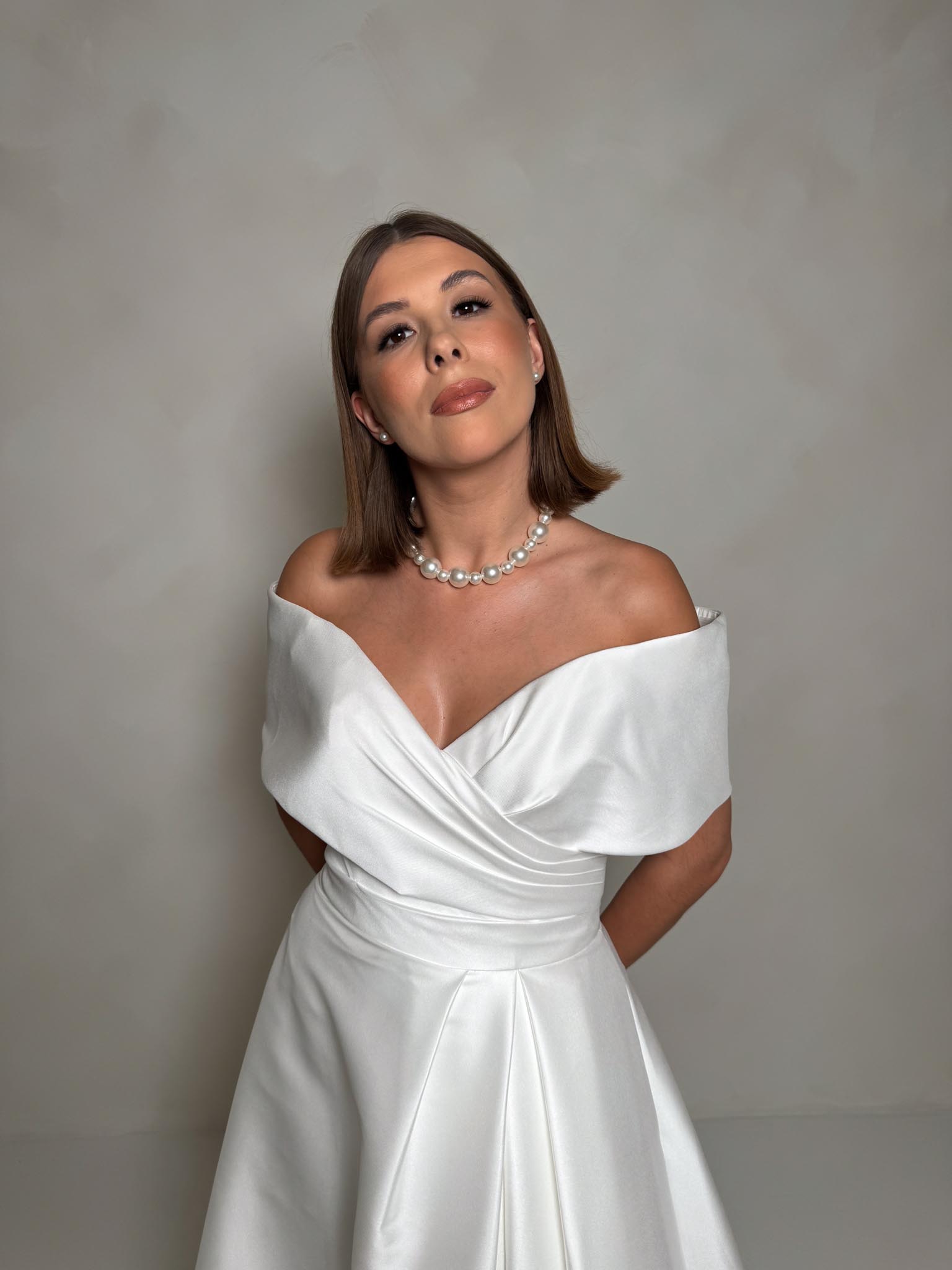 Zjawiskowa i elegancka suknia ślubna z Mikado o kroju litery A. Jest ona idealna dla panien młodych, które chcą pokazać swoją najbardziej elegancką stronę i czuć się pięknie. Suknia z delikatnym odsłaniającym ramiona dekoltem, gorsetem, który podkreśla talię i spódnicą, która nie ma wielu warstw i jest bardzo delikatnie rozkloszowana.